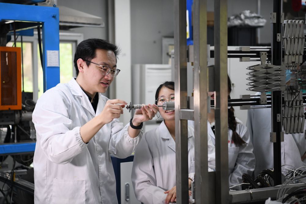 2024年4月6日,在位于安徽合肥的中国科学技术大学,安徽省先进功能高分子薄膜工程实验室团队成员朱健和(左)在和同事讨论实验设备的设计方案。